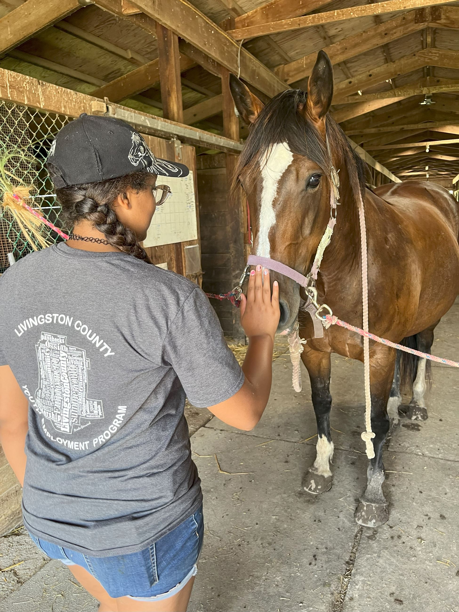 Shayla pets a horse at the farm.  