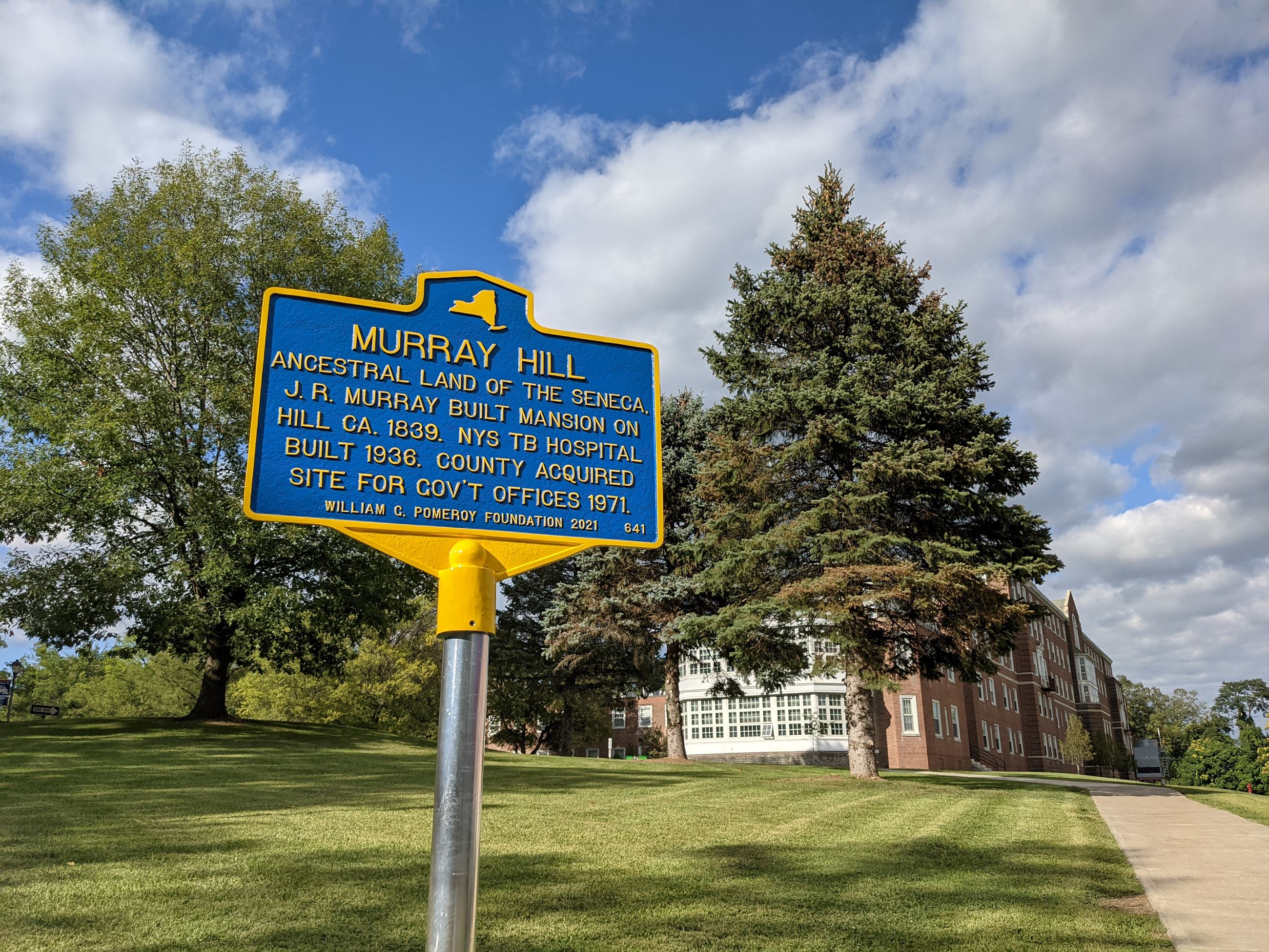 Image of Murray Hill historical marker with old tuberculosis hospital building in background